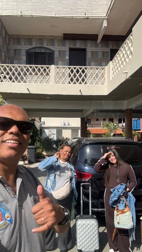Elton com passageiras e bagagem ao lado do veículo